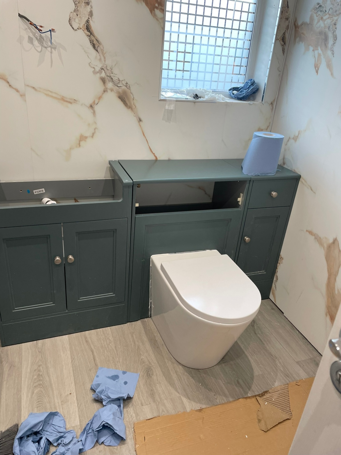 Bespoke fitted vanity and WC unit in dark green with marble wall tiles, bathroom installation by Ash Villa Development